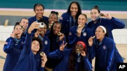 Members of the United States team pose for a picture with their gold medals at Bercy Arena at the 2024 Summer Olympics, in Paris, France, Aug. 11, 2024.