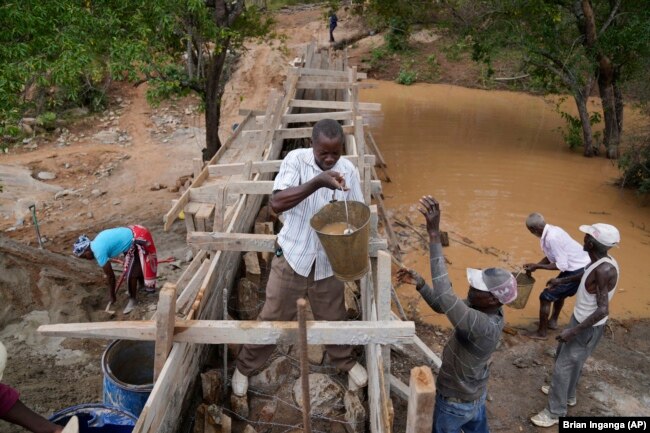 Residents in Machakos County, Kenya, build a sand dam on Thursday, Feb. 29, 2024. Sand dam helps minimize water loss through evaporation and recharges groundwater. (AP Photo/Brian Inganga)