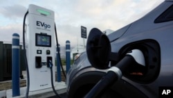 FILE - An electric vehicle charges at an EVgo station in Detroit on Nov. 16, 2022. The Biden administration is proposing new automobile pollution limits that would require as many as two-thirds of new vehicles sold in the U.S. to be electric by 2032.