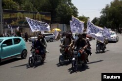 Anggota Taliban membawa bendera mengendarai sepeda motor dalam rangka memperingati ulang tahun ketiga Taliban berkuasa, di Kabul, Afghanistan, 14 Agustus 2024. (Sayed Hassib/REUTERS)