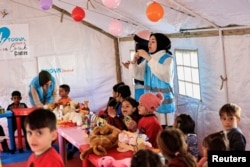 FILE - Volunteers sing with children during an activity to entertain and support the mental health of children affected by the deadly earthquake, at a camp for survivors, in Adiyaman, Turkey, February 18, 2023. (REUTERS/Thaier Al-Sudani/File Photo)