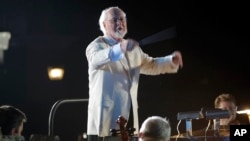 FILE - In this file photo dated June 16, 2010, John Williams leads the Orlando Philharmonic Orchestra during the grand opening celebration at the Wizarding World of Harry Potter at Universal Orlando Resort theme park in Orlando, Florida.