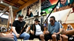 Mark Erickson, third from left, leads others in singing on the drum during an open drum and dance night at Minneapolis American Indian Center, July 10, 2024, in Minneapolis, Minnesota.