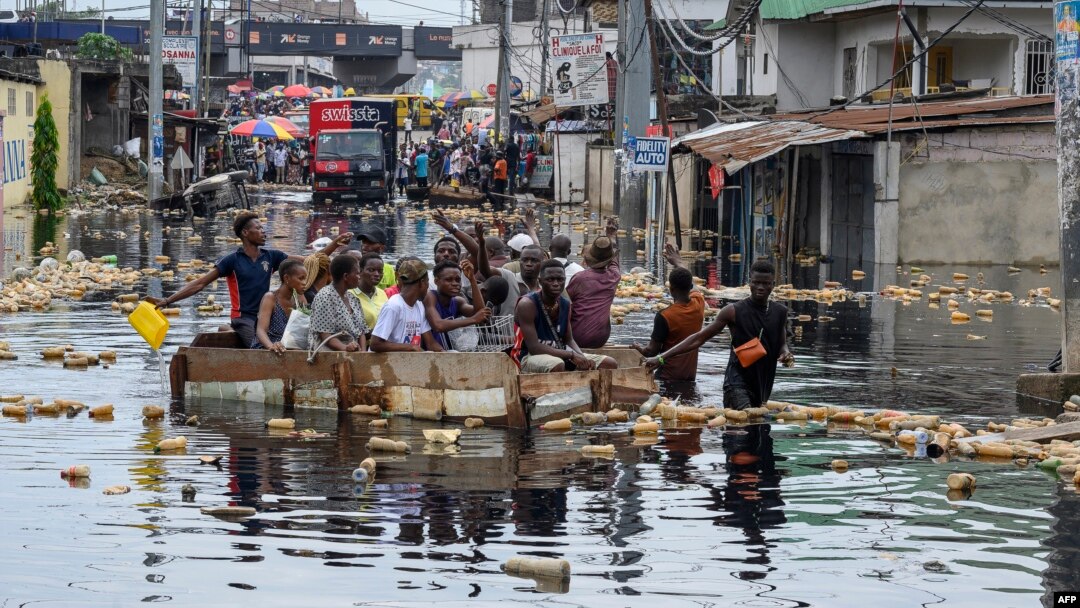 Warga menyeberangi banjir di distrik Pompage di Kinshasa, Republik Demokratik Kongo, pada 9 Januari 2024. (Foto: AFP)