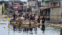 Warga menyeberangi banjir di distrik Pompage di Kinshasa, Republik Demokratik Kongo, pada 9 Januari 2024. (Foto: AFP)