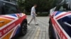 FILE - A man walks past Mini cars decorated with the British flag, outside a showroom in Beijing, China, June 27, 2016.