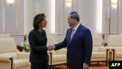 Menteri Perdagangan AS Gina Raimondo berjabat tangan dengan Perdana Menteri China Li Qiang dalam sebuah pertemuan di Beijing pada 29 Agustus 2023. (Foto: Andy Wong/Pool/AFP)