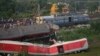 Onlookers are seen gathered as crews work at the site of a deadly train derailment in Balasore district, in the eastern Indian state of Odisha, June 4, 2023.