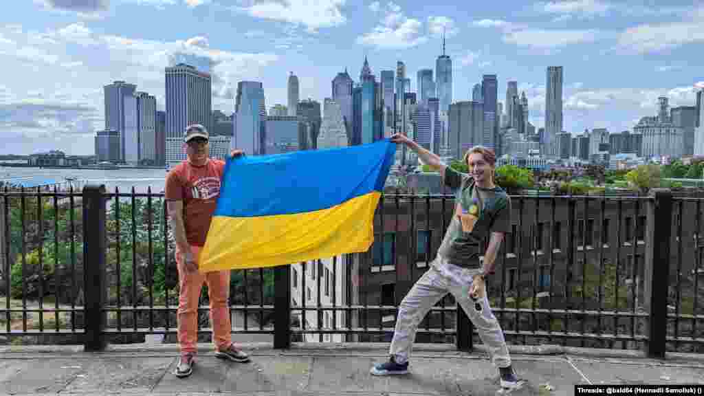 Батько Геник із сином Фредом вітають українців зі святом. Вони розгорнули прапор України на тлі острова Мангеттен, штат Нью-Йорк.