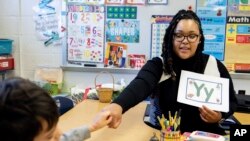 Student teacher Lana Scott, who plans to graduate from Bowie State University in the spring of 2023, teaches a small group of kindergartners at Whitehall Elementary School the alphabet, Tuesday, Jan. 24, 2023, in Bowie, Md.