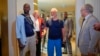 Released hostages French journalist Olivier Dubois, left, and American aid worker Jeffery Woodke, center, arrive at the VIP lounge at the airport in Niamey, Niger, March 20, 2023.