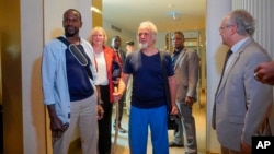 Released hostages French journalist Olivier Dubois, left, and American aid worker Jeffery Woodke, center, arrive at the VIP lounge at the airport in Niamey, Niger, March 20, 2023.