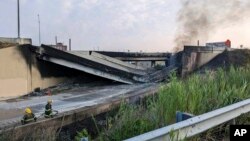 This image provided by the Office of Emergency Management shows firefighters standing near the collapsed part of I-95 in Philadelphia, June 11, 2023.