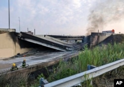 This image provided by the Office of Emergency Management shows firefighters standing near the collapsed part of I-95 in Philadelphia, Sunday, June 11, 2023.