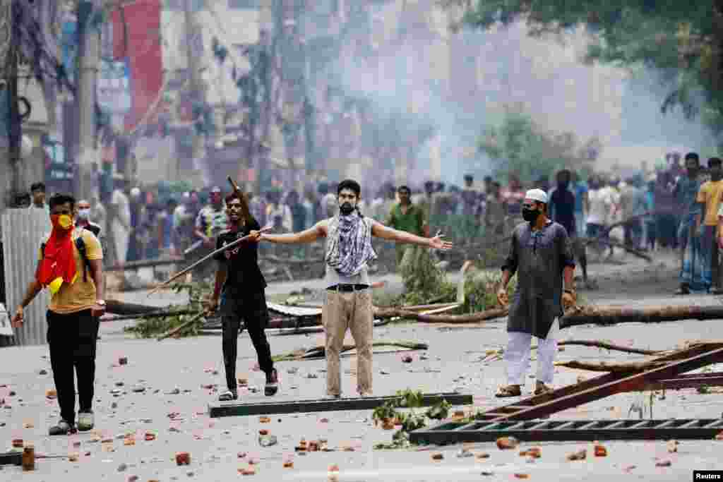 A demonstrator gestures as protesters clash with Border Guard Bangladesh (BGB) and the police outside the state-owned Bangladesh Television as violence erupts across the country after anti-quota protests by students, in Dhaka, Bangladesh.