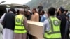 巴基斯坦志愿者在香拉区贝舍姆市一家医院运送遭自杀炸弹袭击而丧生的中国公民的棺柩。（2024年3月26日）