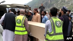巴基斯坦志愿者在香拉区贝舍姆市一家医院运送遭自杀炸弹袭击而丧生的中国公民的棺柩。（2024年3月26日）