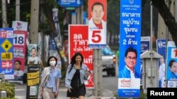 FILE - People walk past electoral campaign posters as Thailand will hold general elections on May 14, in Bangkok, Thailand, April 26, 2023. (REUTERS/Chalinee Thirasupa/File Photo)