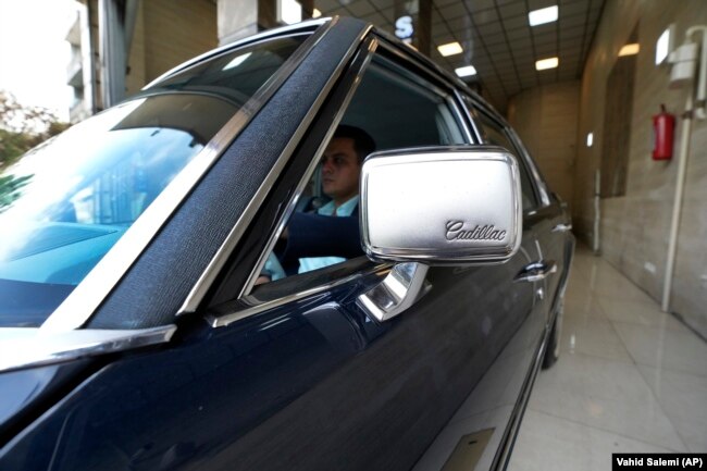 Khosro Dahaghin drives out his restored Cadillac Seville at his dealership store in Roudehen, some 30 miles (45 kilometers) east of downtown Tehran, Iran, Wednesday, June 7, 2023.(AP Photo/Vahid Salemi)