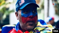 ARCHIVO - Esta imagen tomada en Caracas, Venezuela en marzo de 2020, muestra a un venezolano maquillado y con una bandera en un evento de protestas de la oposión en el país sudamericano.