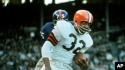 FILE - Jim Brown, Hall of Fame running back for the Cleveland Browns, is shown in action against the New York Giants in Cleveland, Ohio, on Nov. 14, 1965. The NFL legend, actor and social activist died at his Los Angeles home on May 18, 2023. He was 87.
