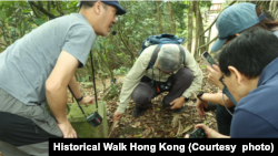 “香港行跡”創辦者之一的何文傑(左)在導賞團中介紹界石。(圖片來源：香港行跡)