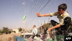 FILE — Police dump confiscated beer in Tehran, July 22, 2009. Selling and drinking alcohol has been banned in Iran since the 1979 Islamic Revolution, giving rise to smuggled or bootleg alcohol, some of it adulterated with poisonous methanol. (Farzin Nemati/AFP)