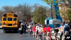 Los niños de The Covenant School se toman de la mano mientras son llevados a un sitio de reunificación en la Iglesia Bautista Woodmont después de un tiroteo mortal en su escuela, en Nashville, Tennessee, el 27 de marzo de 2023.