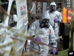FILE - Personnel in protective gear work on a van in Winterslow, England, on March 12, 2018, as investigations continued into the nerve-agent poisoning of Russian ex-spy Sergei Skripal and his daughter Yulia in Salisbury, England.