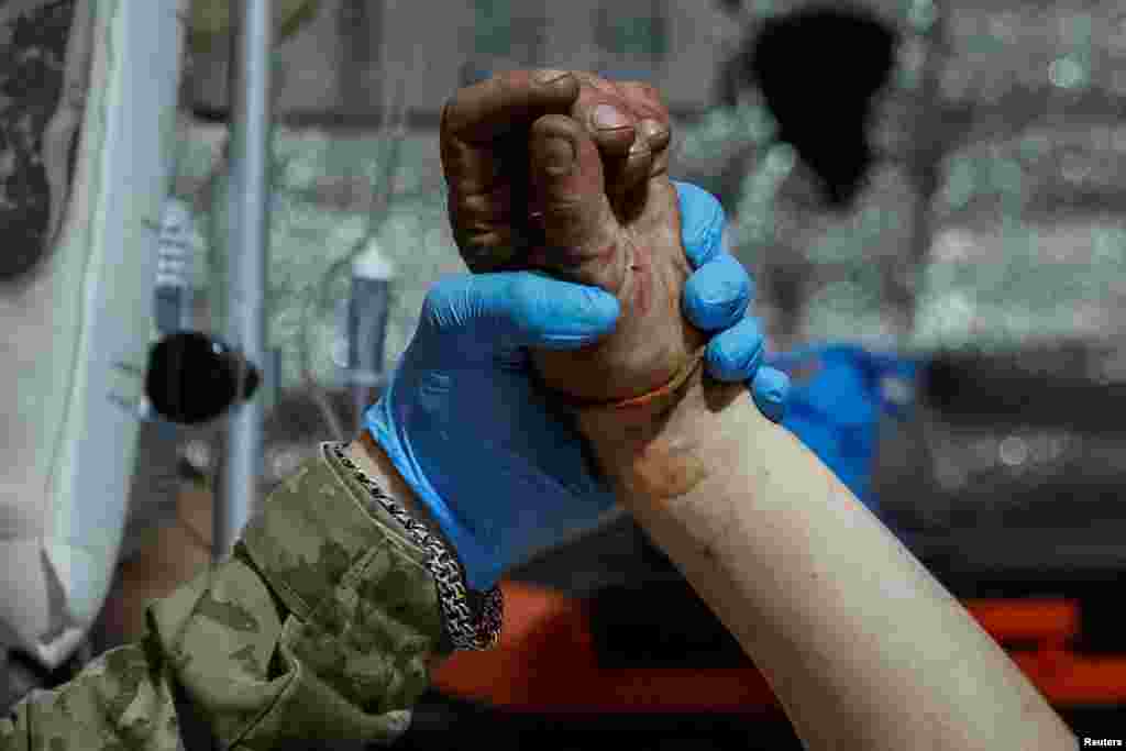 Un médico sostiene la mano de un soldado herido tras los últimos combates de las fuerzas ucranianas contra el avance de Rusia en el este de Ucrania, cerca de la ciudad de Chasiv Yar, en la región de Donetsk, el 1 de julio de 2024.&nbsp;