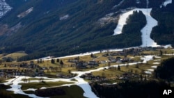 FILE - People ski on a strip of snow near Schladming, Austria, Friday, Jan. 6, 2023. 