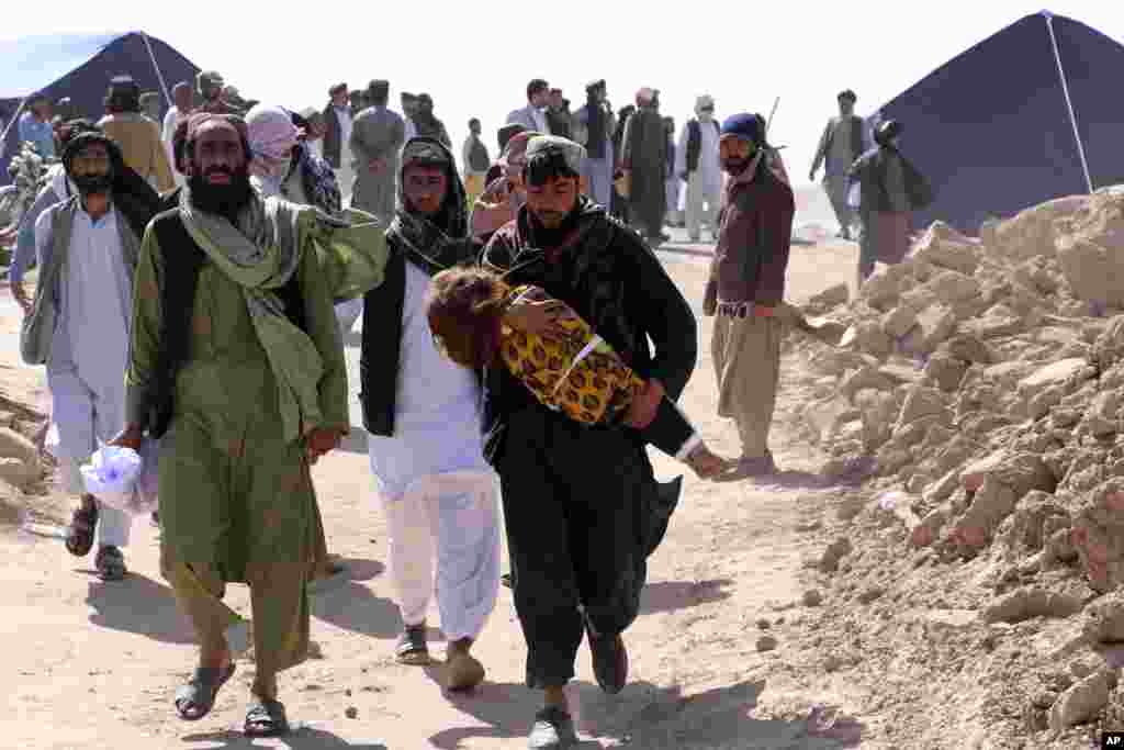 Warga Afghanistan membawa jenazah seorang anak setelah gempa bumi di distrik Zenda Jan di provinsi Herat, Afghanistan barat. Gempa bumi dahsyat menewaskan sedikitnya 2.000 orang di Afghanistan barat, kata juru bicara pemerintah Taliban.