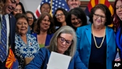 Arizona Gov. Katie Hobbs signs the repeal of Civil War-era near-total abortion ban, May 2, 2024, at the Capitol in Phoenix. 