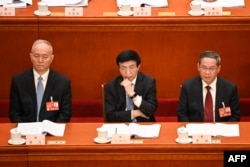 左起：中共中央政治局常委蔡奇、王沪宁（左）与李强在人大会堂出席全国人大会议。（2023年3月7日）