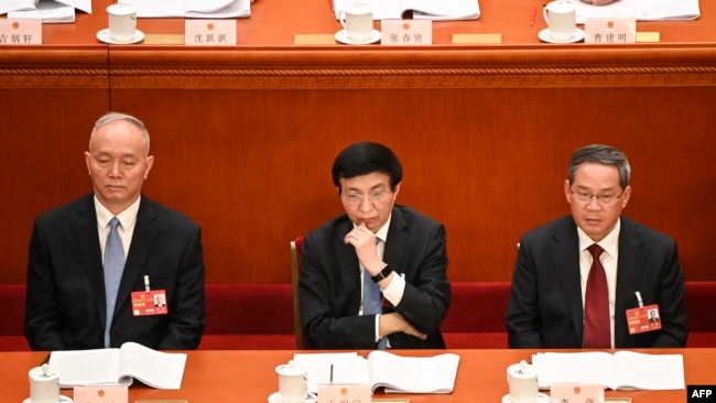 中共中央书记处书记蔡奇（左）、全国政协主席王沪宁（中）与国务院总理李强在中国人民大会堂出席全国人大会议。（2023年3月7日）