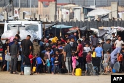 Pengungsi Palestina mengantre untuk membeli air dari truk air di sebelah kamp sementara mereka di Rafah di tengah konflik yang sedang berlangsung antara Israel dan kelompok militan Hamas, 17 Mei 2024. (Foto: AFP)