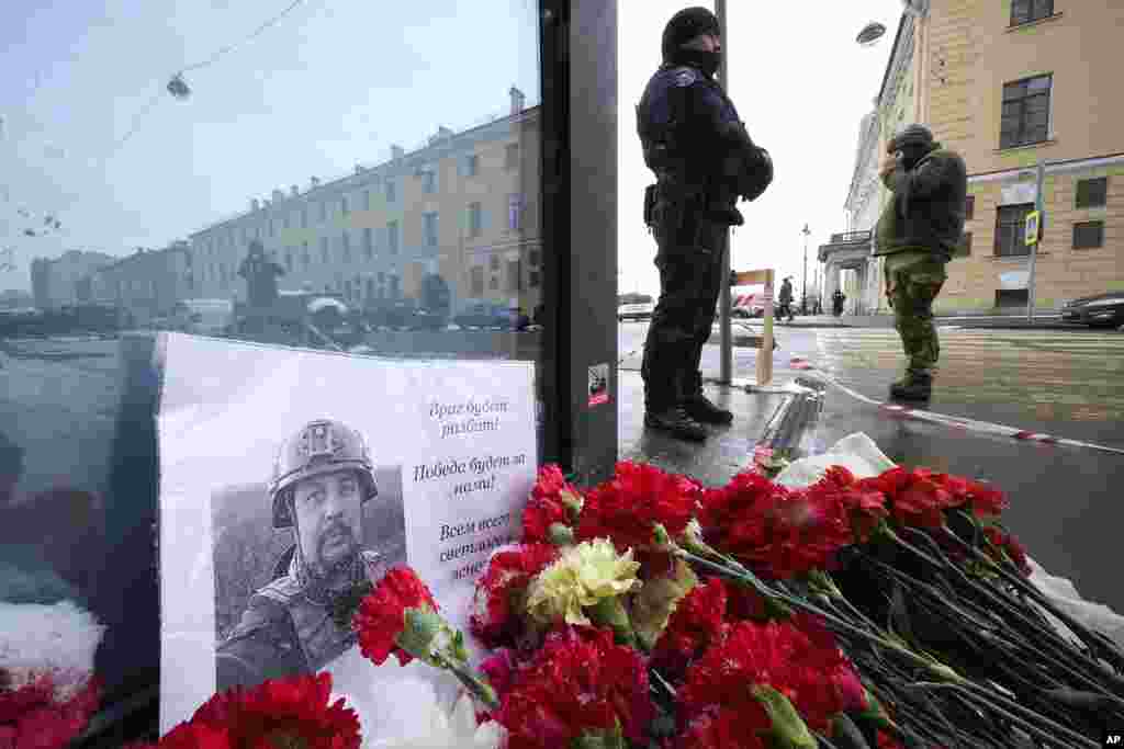 Flowers and a poster with a photo of blogger Vladlen Tatarsky are placed near the site of an explosion at the Street Bar cafe in St. Petersburg, Russia. An explosion tore through a cafe in Russia&#39;s second-largest city, killing the well-known military blogger and strident supporter of the war in Ukraine. Some reports said a bomb was embedded in a bust of the blogger that was given to him as a gift. Russian officials said Tatarsky was killed Sunday as he led a discussion at the cafe in the historic heart of St. Petersburg.