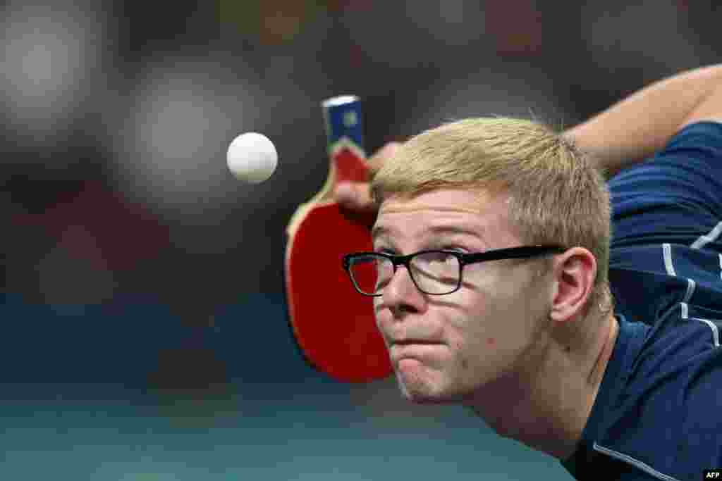 France&#39;s Felix Lebrun eyes the ball while serving during his men&#39;s table tennis singles match in the team semifinal between China and France at the Paris 2024 Olympic Games at the South Paris Arena in Paris.