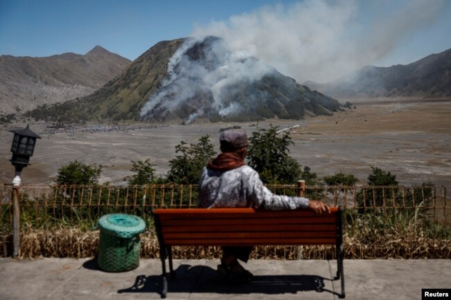 Seorang pria menyaksikan asap membubung dari Gunung Batok, di Taman Nasional Bromo Tengger Semeru, Probolinggo, Jawa Timur, 22 Juni 2024. (REUTERS/Willy Kurniawan)