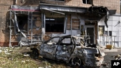 A burned car is seen in front of an apartment building damaged after shelling by the Ukrainian side in Kursk, Russia, Aug. 11, 2024. 