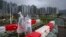 People in rain coats walk past sandbagged barricades set up for Typhoon Saola as it passes through Lei Yue Mun district in Hong Kong on Sept. 2, 2023.