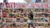 Seorang pejalan kaki melintas di depan foto-foto orang Israel yang disandera oleh kelompok Hamas Palestina saat serangan 7 Oktober, di tengah konflik Israel-Hamas, di Tel Aviv, Israel, 10 Juni 2024. (Foto: Marko Djurica/Reuters)