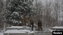 Binh sĩ Ukraine nghỉ ngơi trong lúc xây dựng hầm trú ẩn cho tuyến phòng thủ mới giữa lúc Nga tấn công gần biên giới Belarus tại Chornobyl, Ukraine, ngày 14/12/2023.