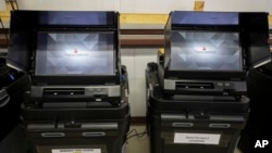 FILE - Dominion Voting ballot-counting machines are shown at a Torrance County warehouse during election equipment testing with local candidates and partisan officers in Estancia, New Mexico, Sept. 29, 2022.