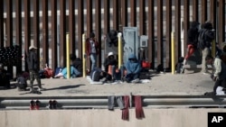 FILE - Migrants wait on the the border between Mexico and the United States, as seen from Ciudad Juarez, Mexico, Jan. 8, 2023. 