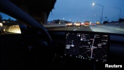 FILE - A Tesla Model 3 vehicle drives on autopilot along the 405 highway in Westminster, California, March 16, 2022. 
