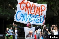 A demonstrator holds a placard outside Manhattan Criminal Court following the verdict in former U.S. President Donald Trump's criminal trial over charges that he falsified business records, in New York City, May 30, 2024.