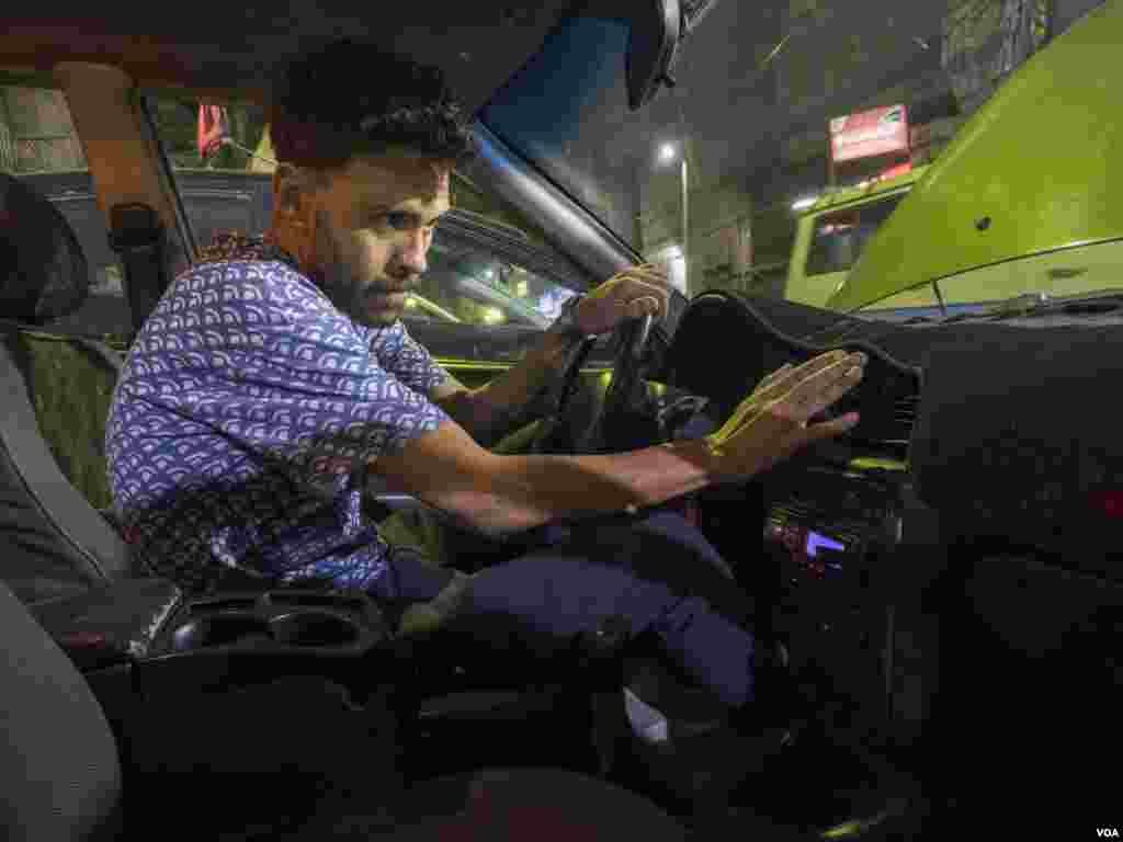 For Samer, a sports photographer, his car’s air conditioning serves as a line of defense against heat stress, as he travels around the capital to document a top Egyptian soccer team’s activities. Cairo, Egypt, May 31, 2024. (Hamada Elrasam/VOA)