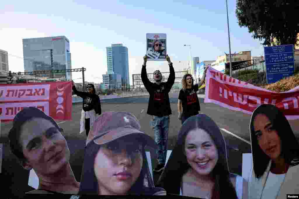 Demonstrators block the main highway as they hold signs with the faces of female hostages held in Gaza since October 7 and to call for their immediate release, in Tel Aviv, Israel.