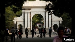 FILE=People walk near the gate of Tsinghua University in Beijing, July 27, 2016.